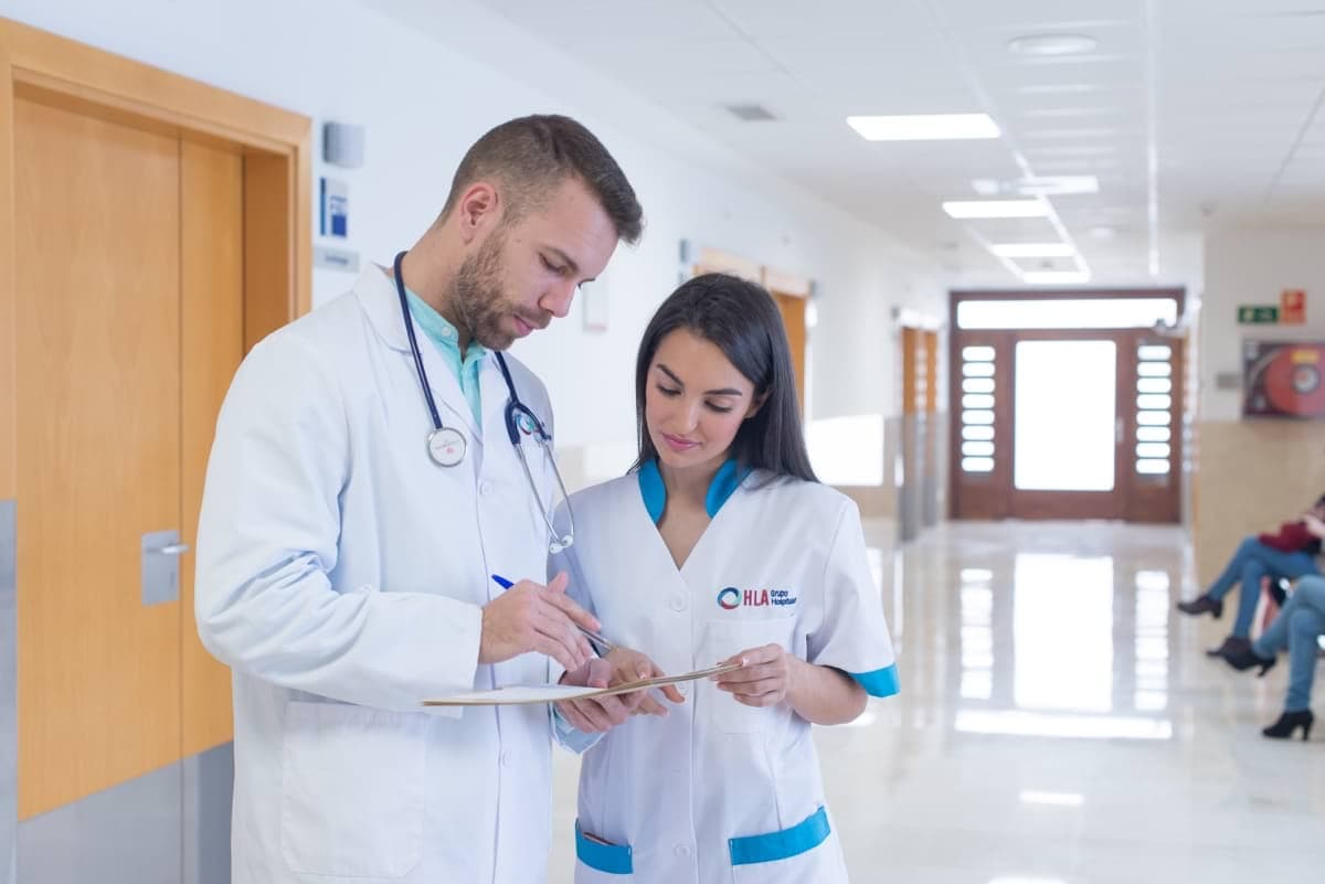Doctor con enfermera firmando un documento